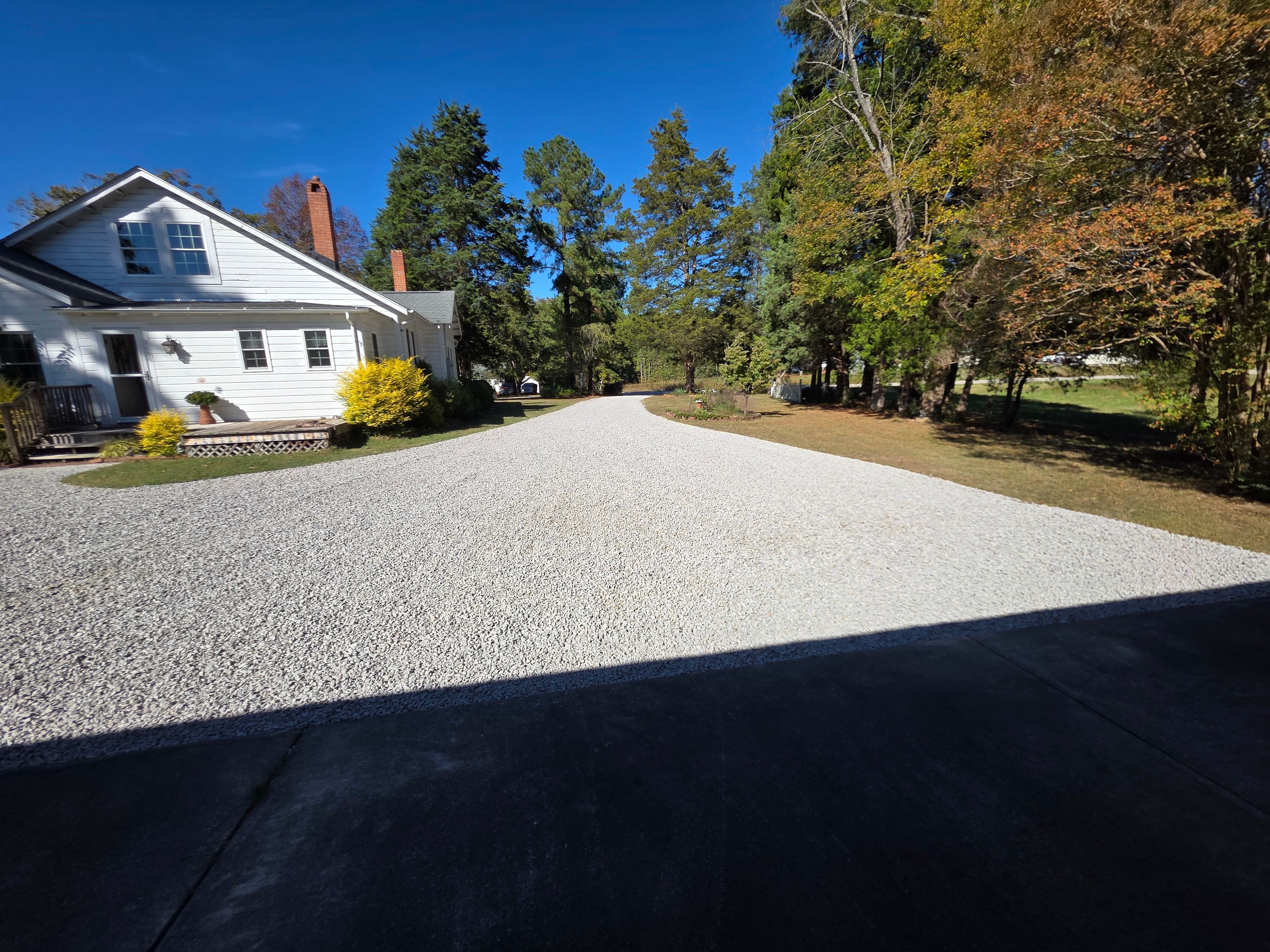 Finished gravel driveway leading to a home after grading and new #57 stone placement