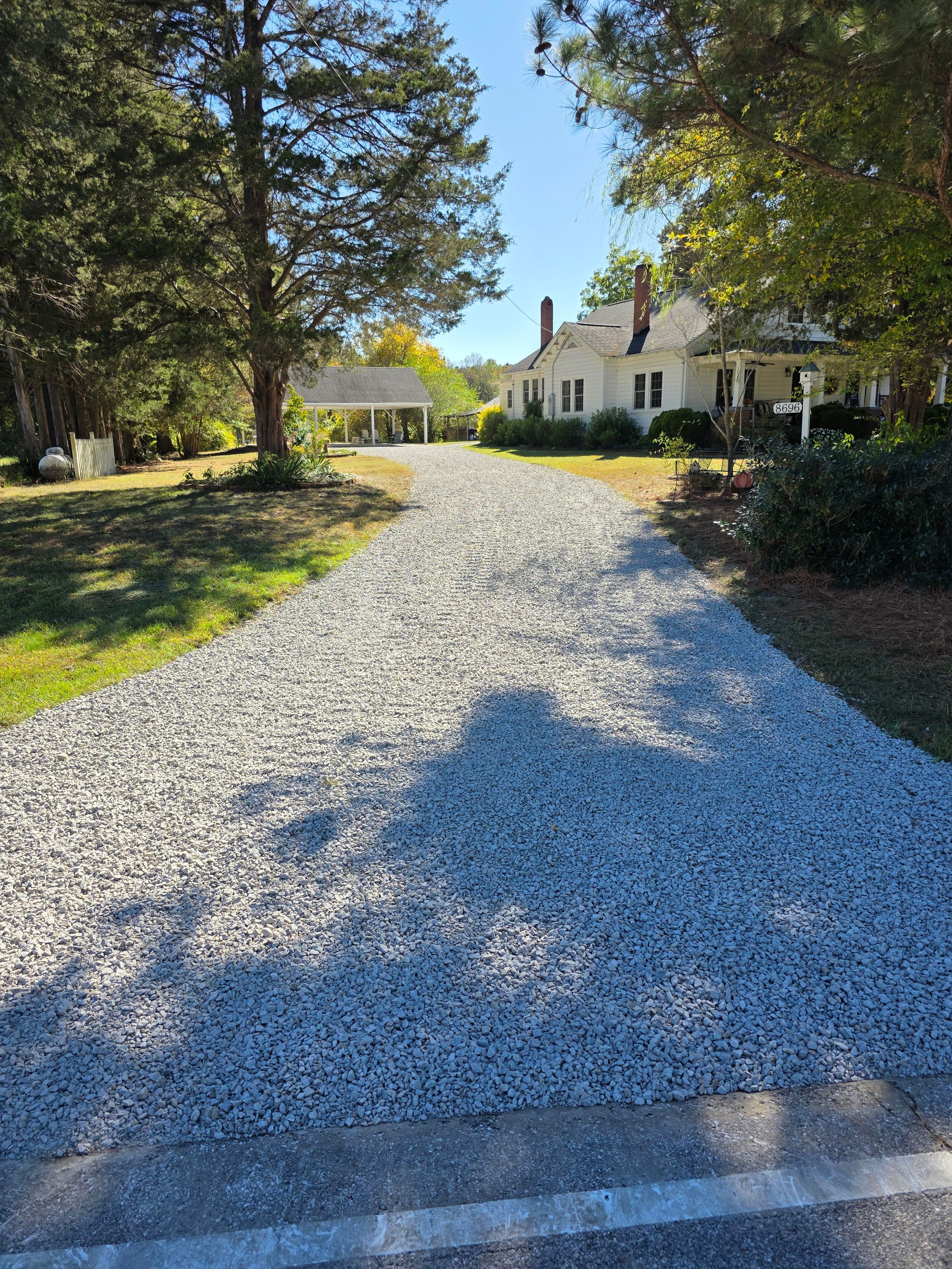 Finished gravel driveway leading to a home after grading and new gravel placement