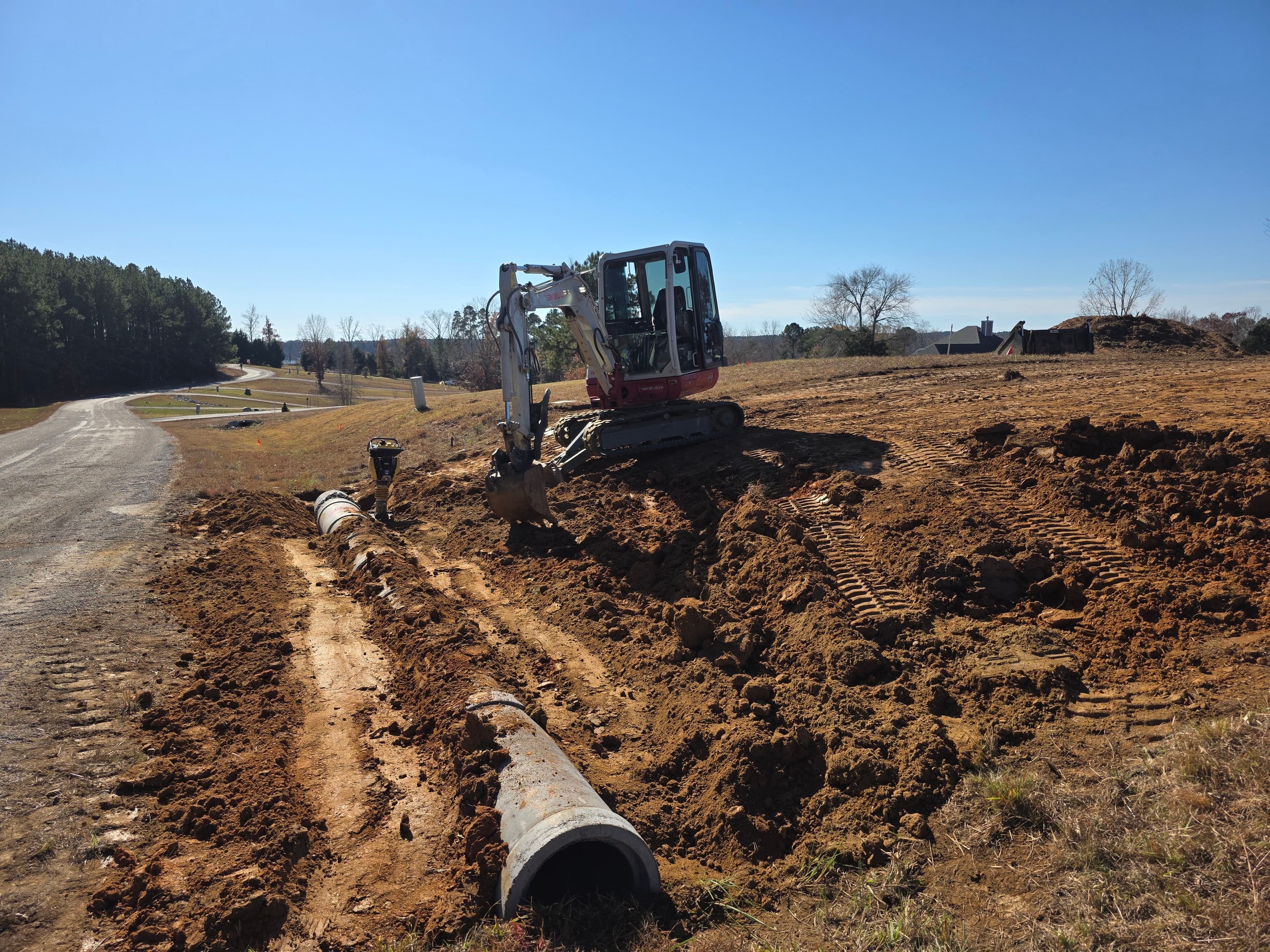 Excavator working on drainage and pipe installation